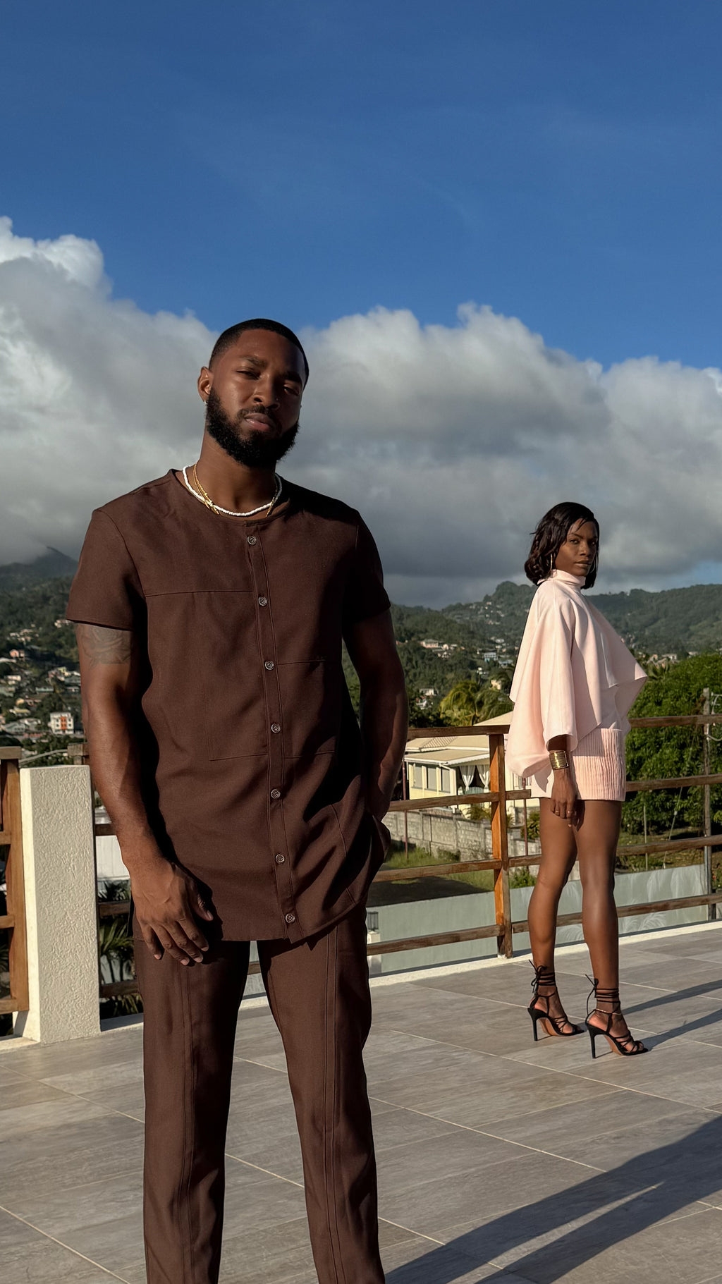 Models standing on a rooftop with a scenic background