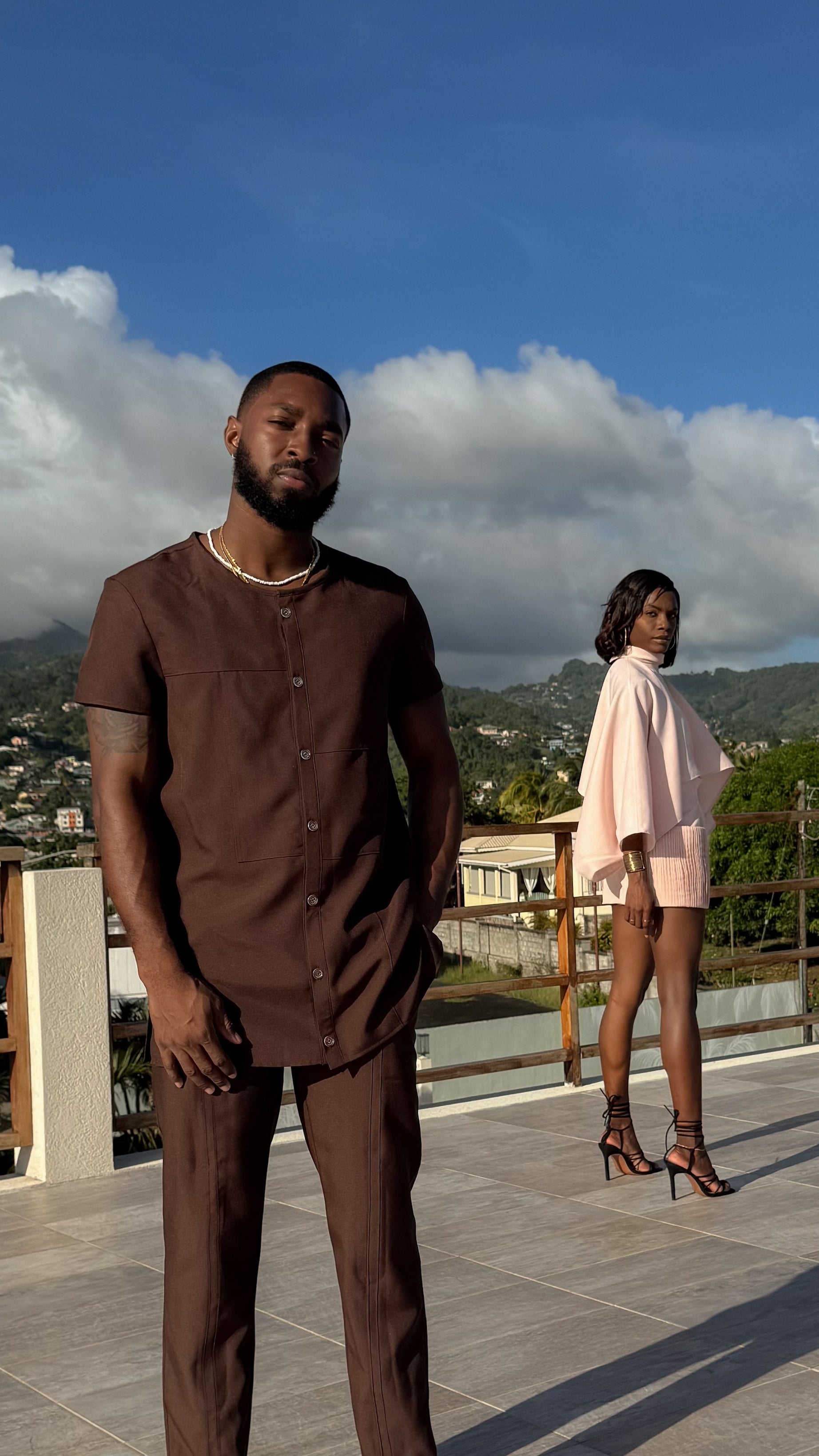 Models standing on a rooftop with a scenic background